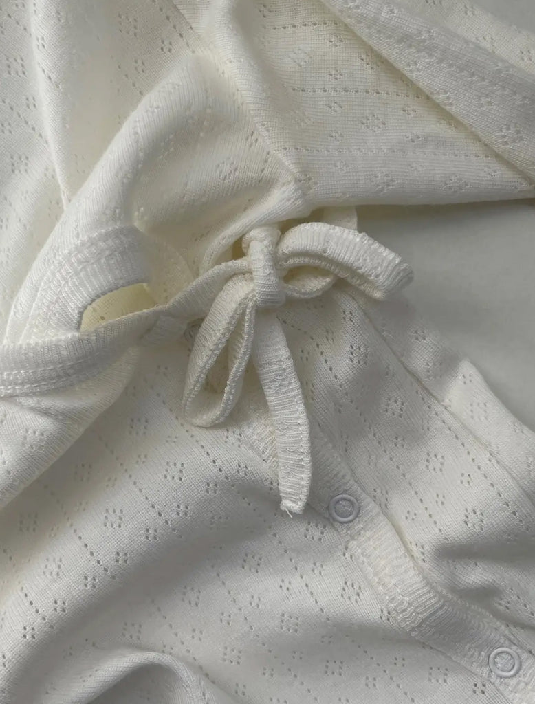 Baby Wrap Sleepsuit in Cream pointelle detailed image.