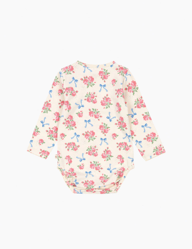 Image of a baby onesie with a floral and bow print on a cream ground.