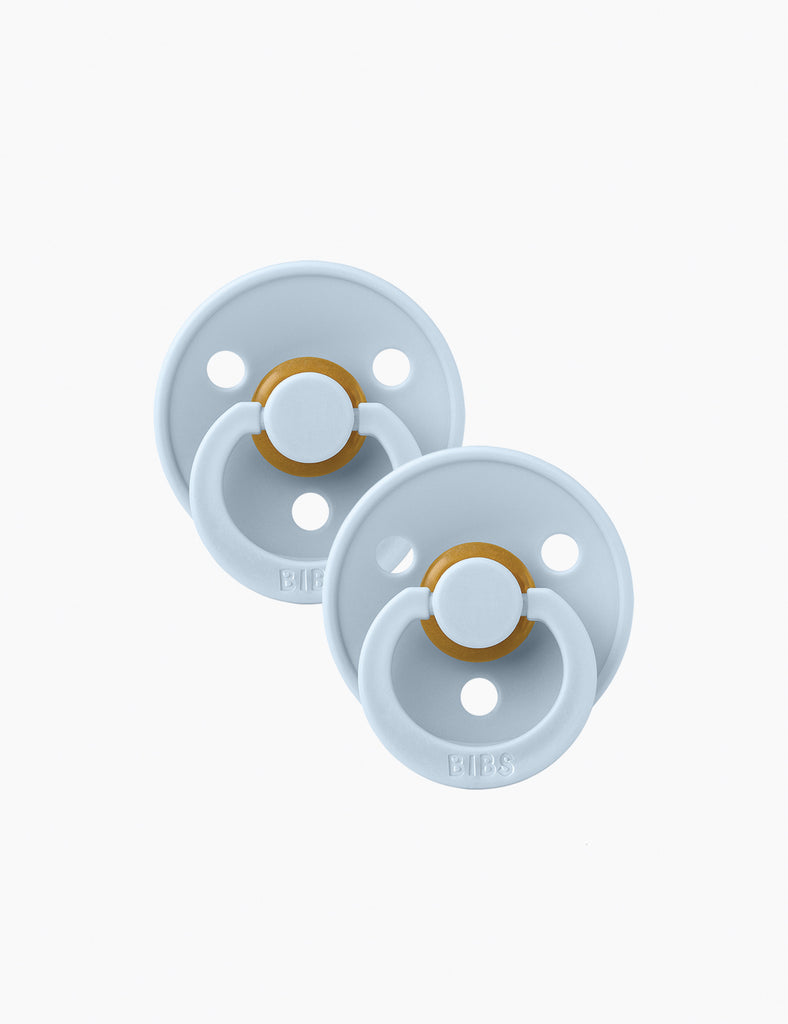 Two light blue pacifiers with gold bands on a white background
