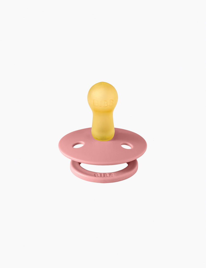 Pink and yellow pacifier on a white background