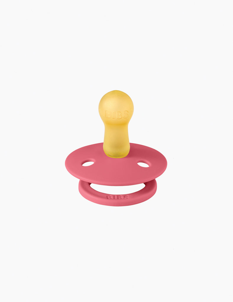 Pink and yellow pacifier on a white background