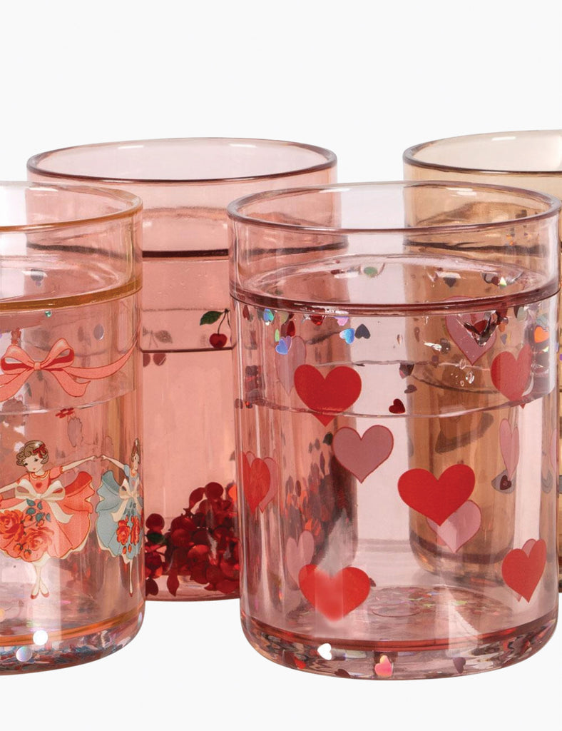 Set of pink glass tumblers with heart designs and a ballerina illustration on a white background