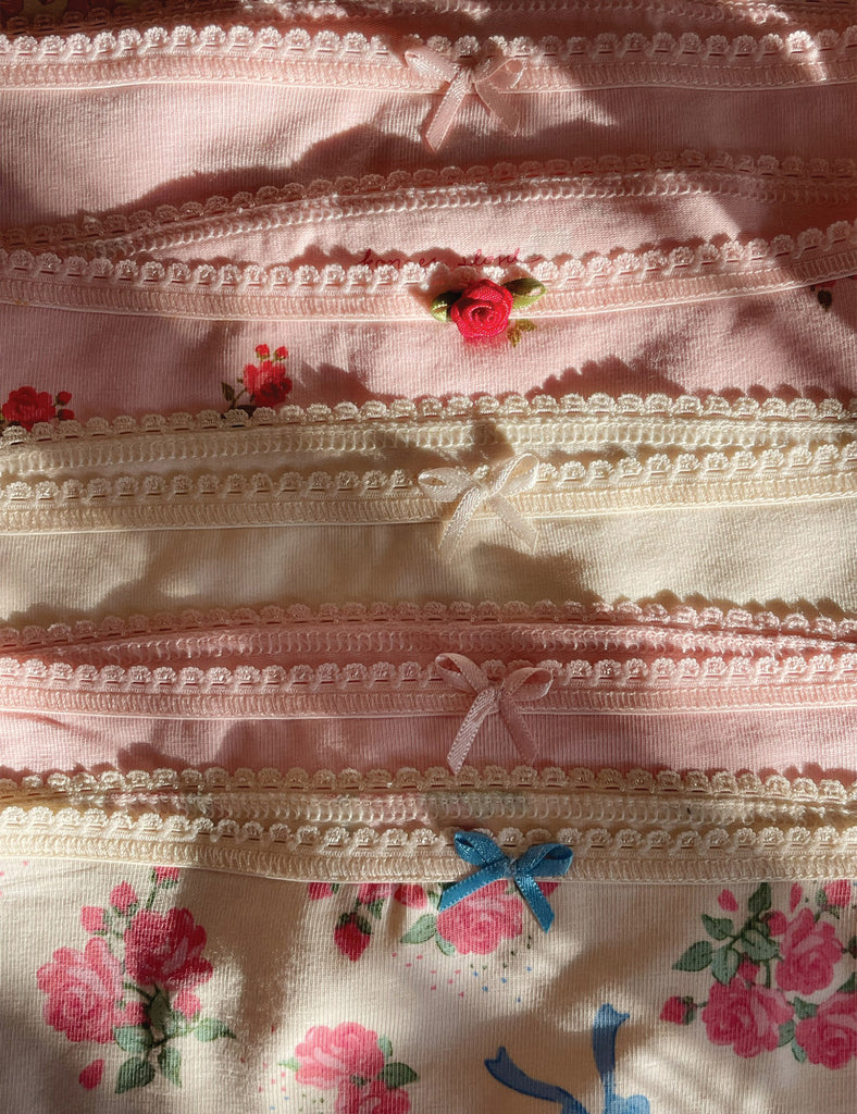 Close-up of a floral fabric with lace trim and embroidered details.