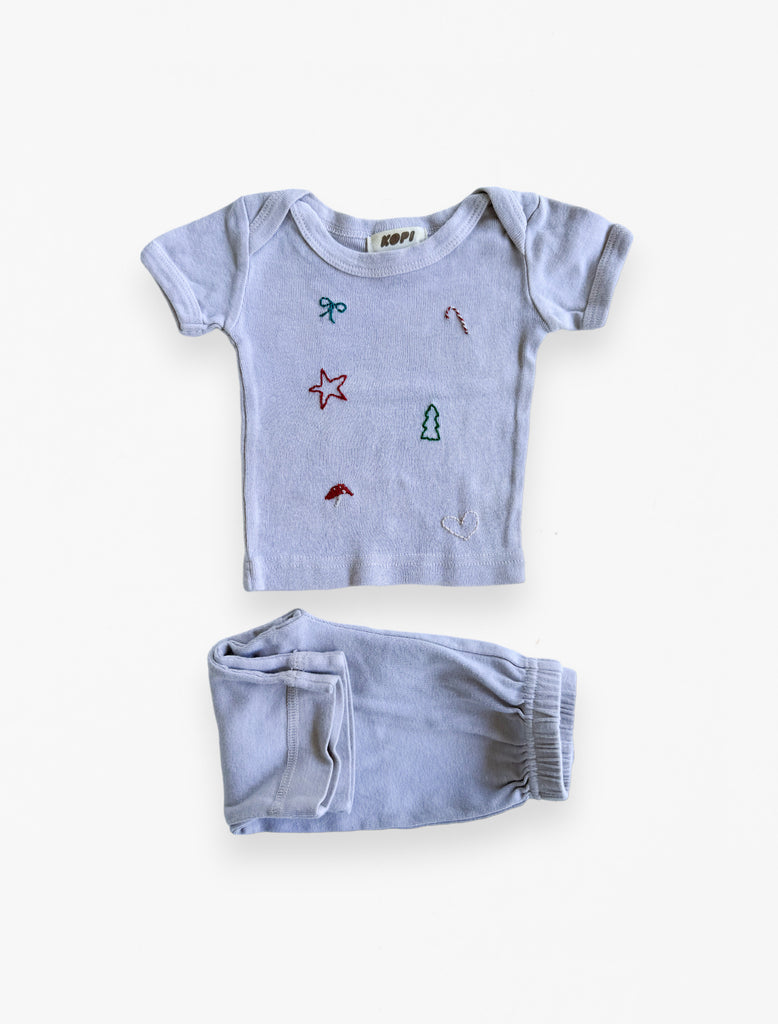 90s holiday baby set in au lait flat lay image.
