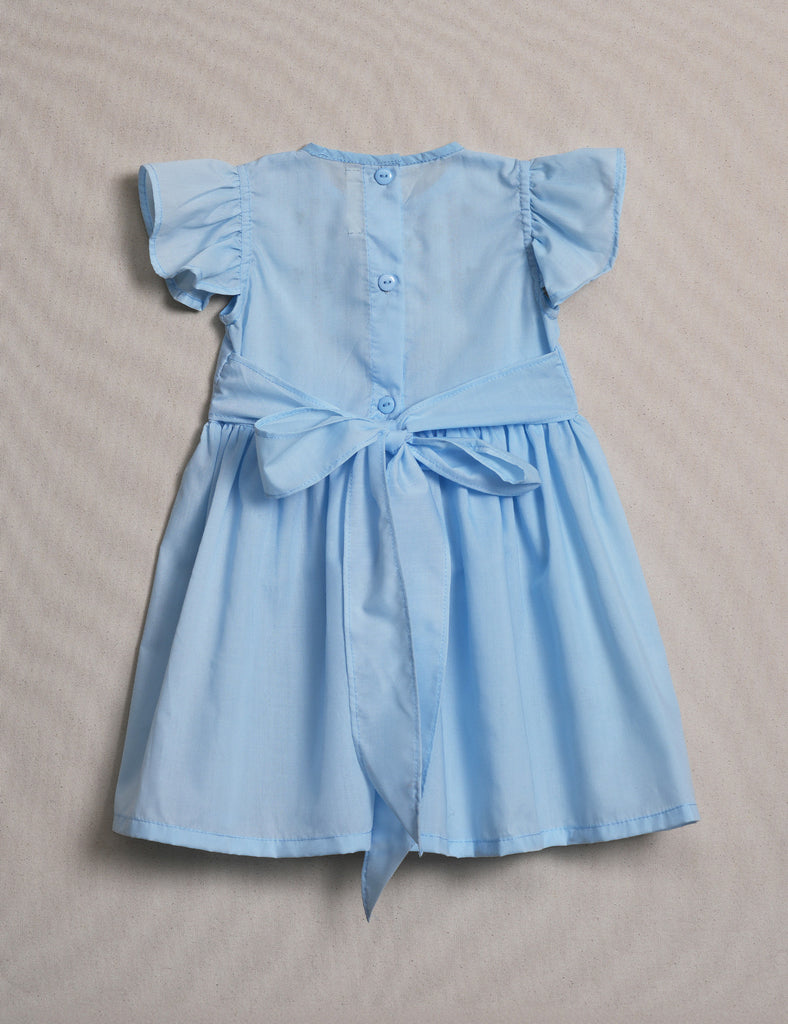 Light blue dress with ruffled sleeves on a beige background