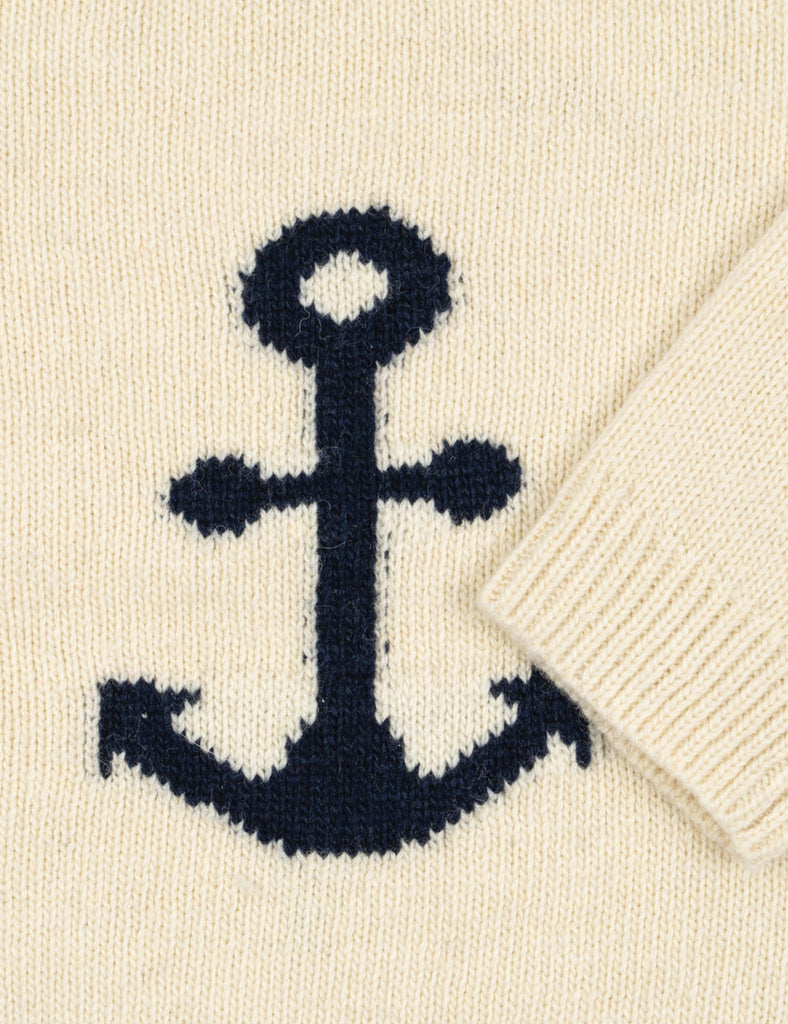 Close-up of a navy anchor design on a cream sweater.