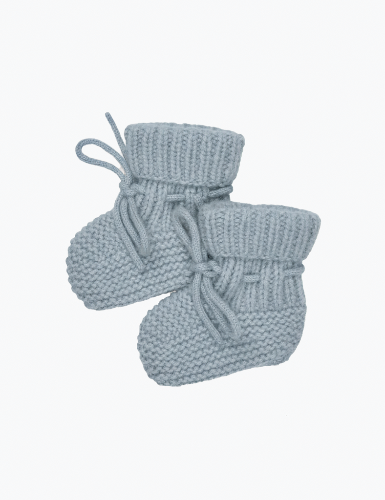 Pair of light blue knitted baby booties on a white background