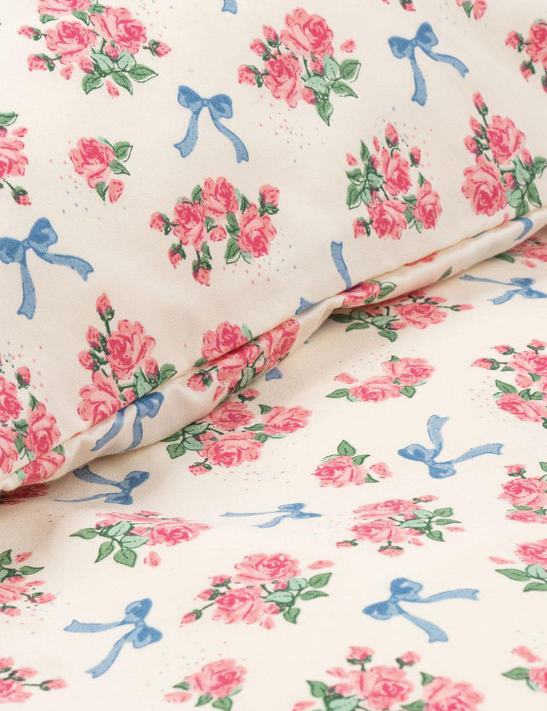 Floral fabric with pink flowers and blue bows on a white background