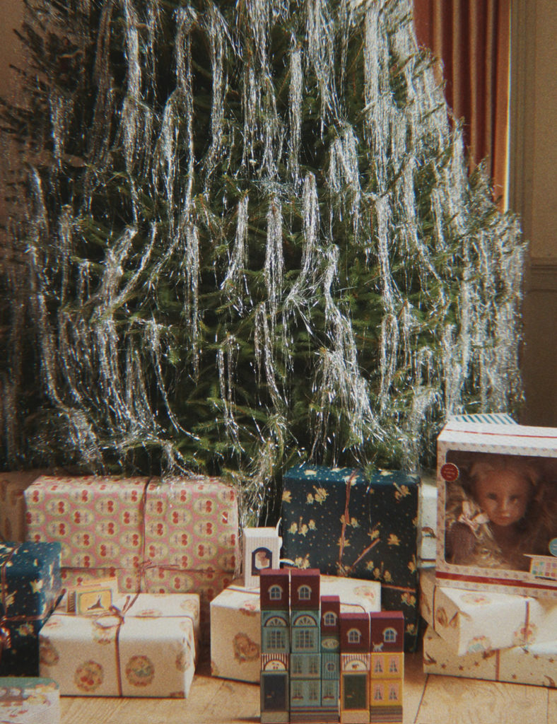Christmas tree with wrapped gifts and a photo box in a room setting