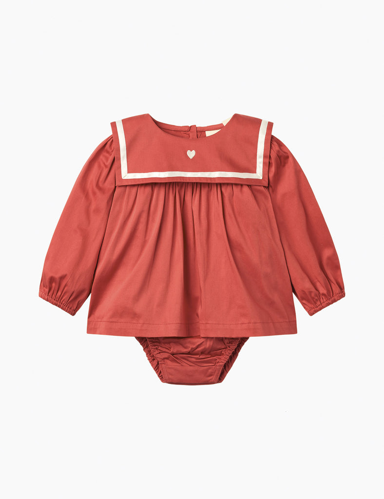 Red baby romper with sailor collar on a white background