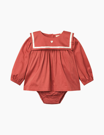 Red baby romper with sailor collar on a white background