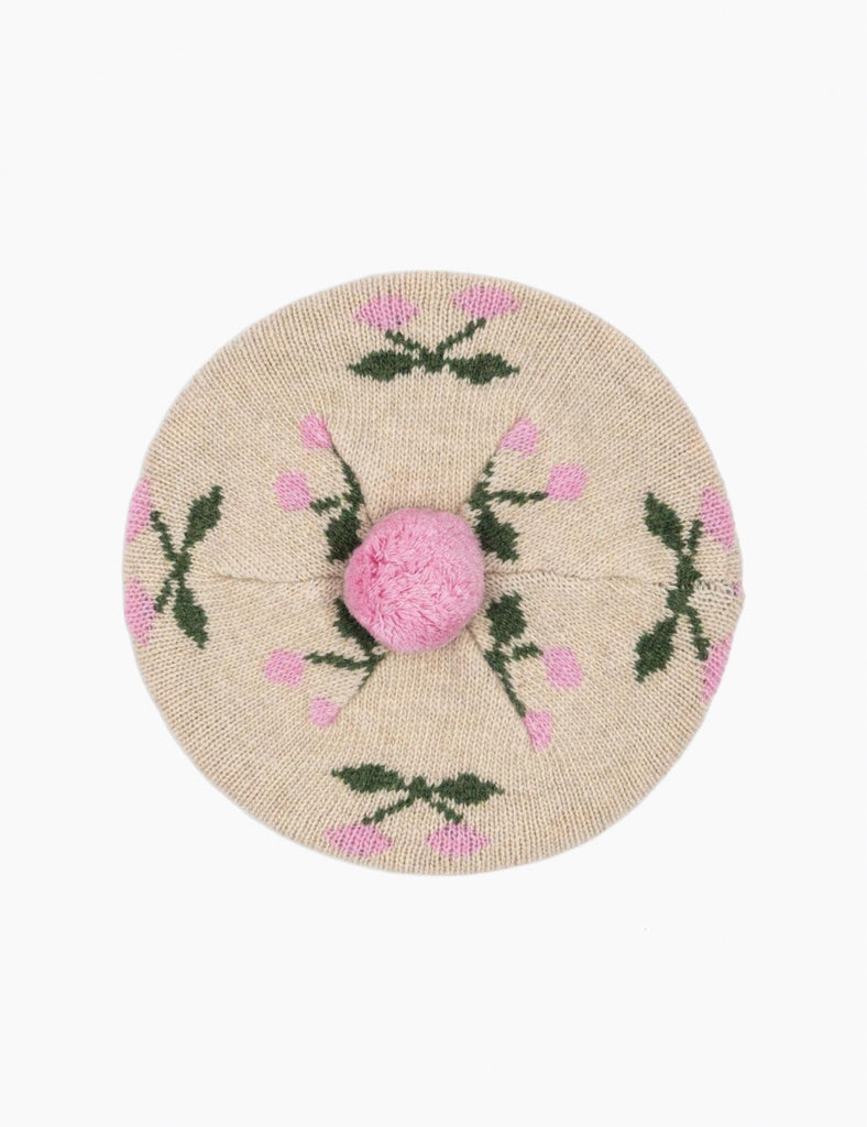 Round knit beret with pink cherry design on a beige background