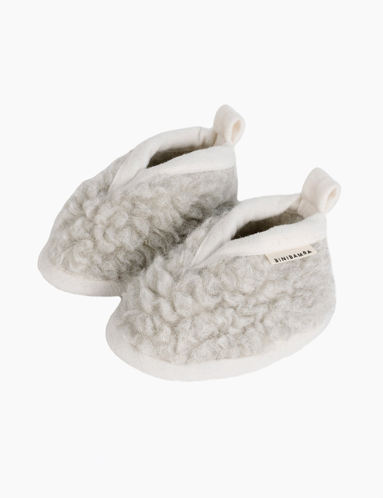 Pair of gray slippers with fluffy texture on a white background
