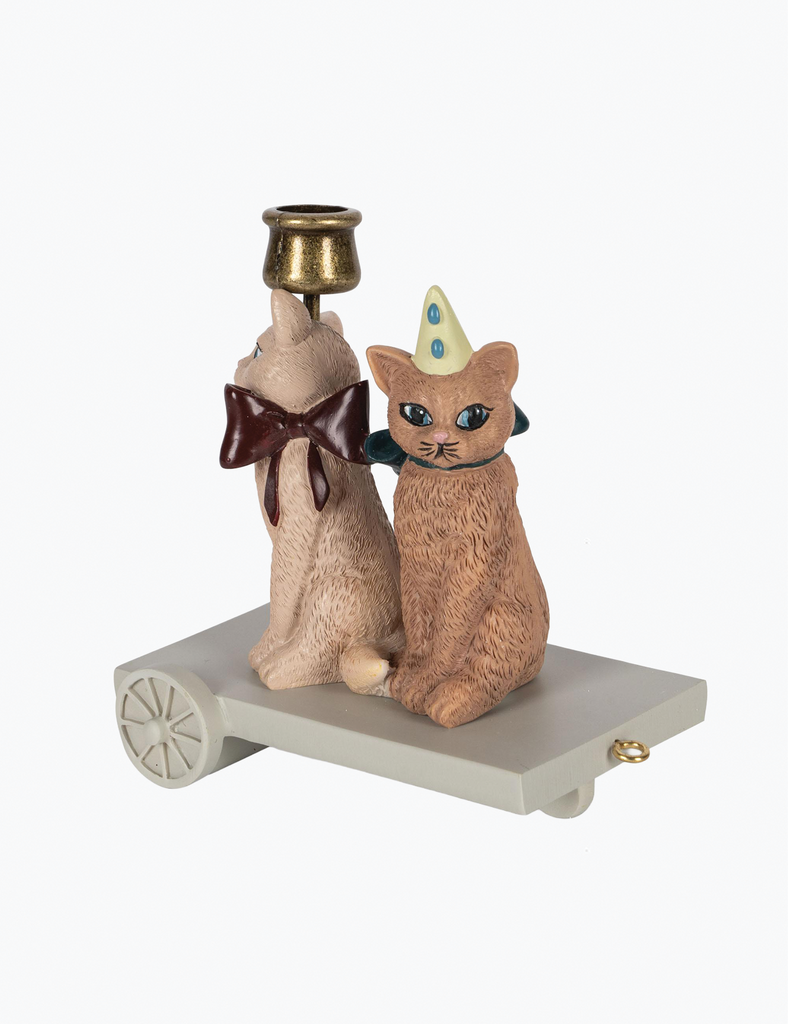 Decorative figurine of two cats with a small bell on a white background