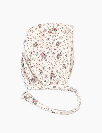 Floral-patterned bonnet with a strap on a white background