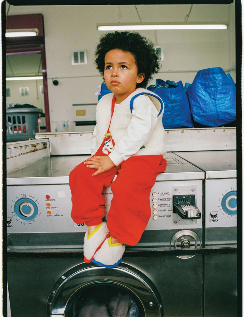 Child sitting on a washing machine in a laundromat