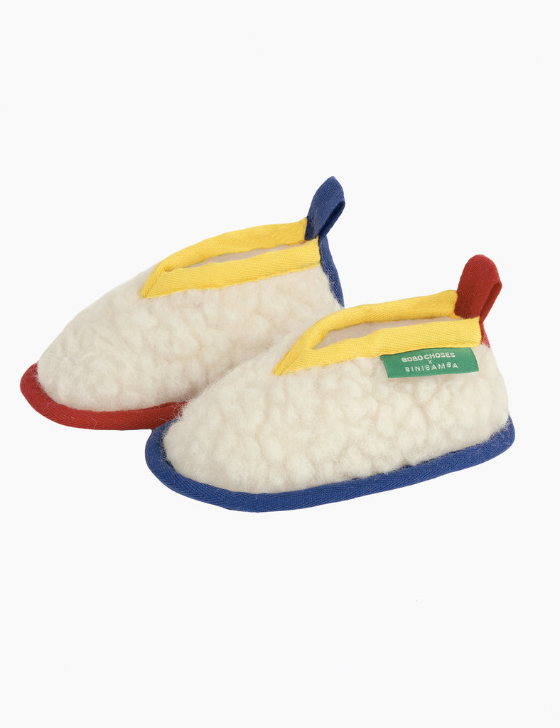 Pair of colorful slippers with a visible brand tag on a white background