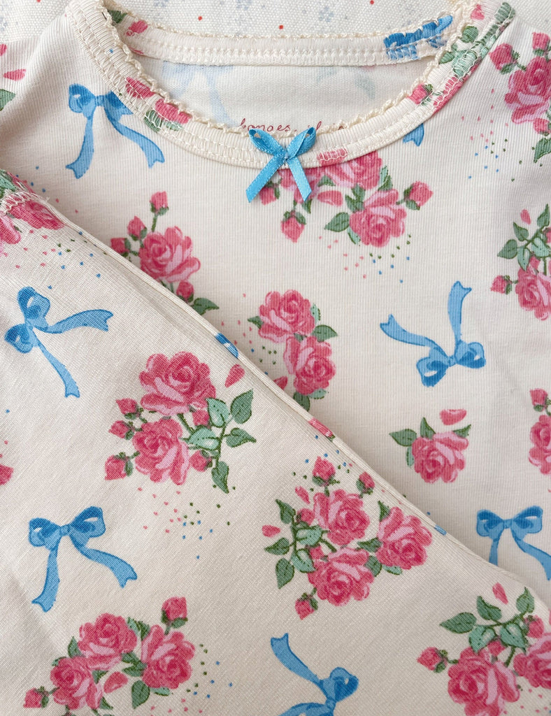 Close up image of the baby bodysuit with the floral and bow print.