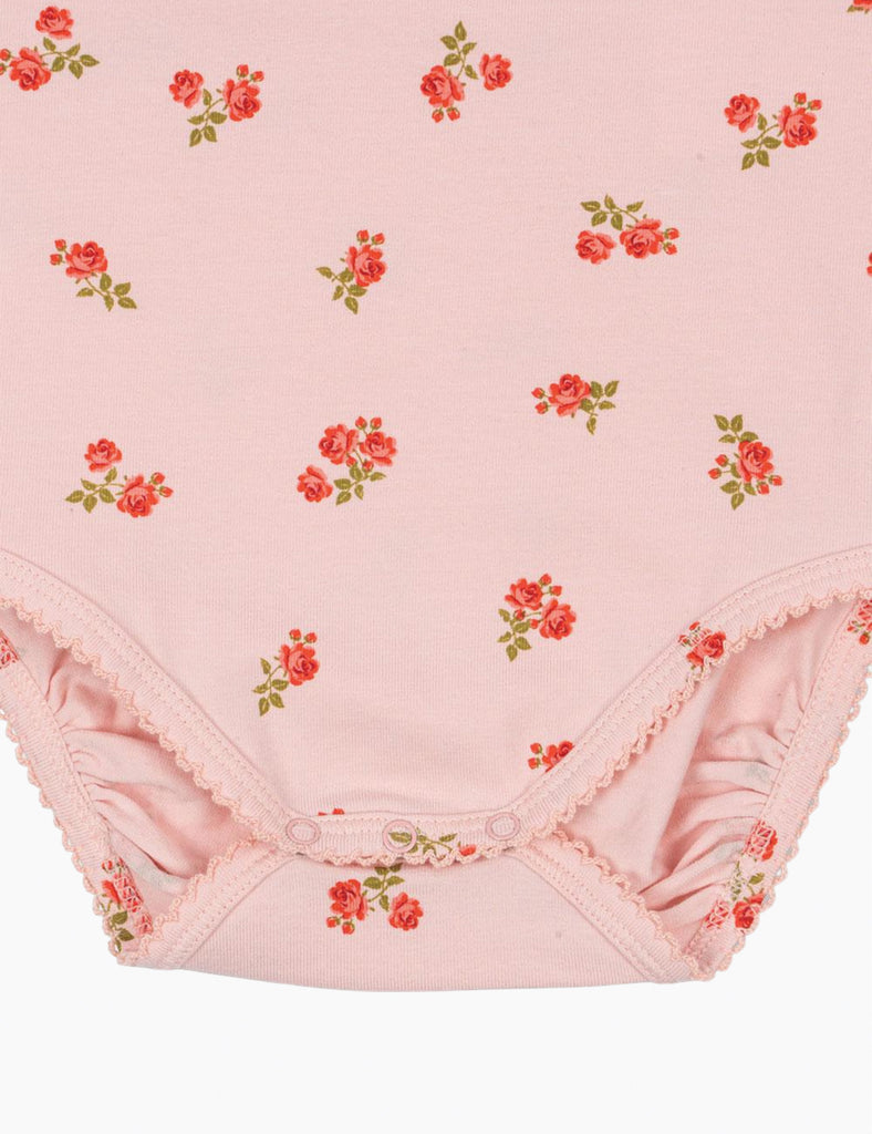 Pink floral-patterned baby bloomers on a pink background