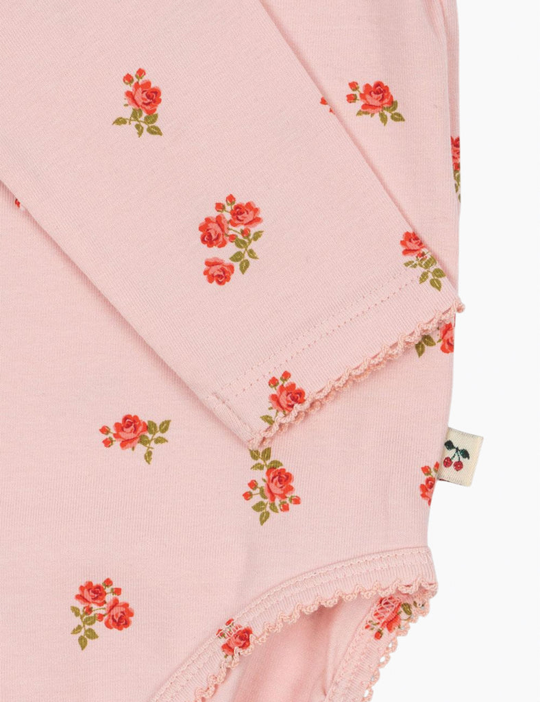 Pink fabric with floral patterns and a tag on a white background