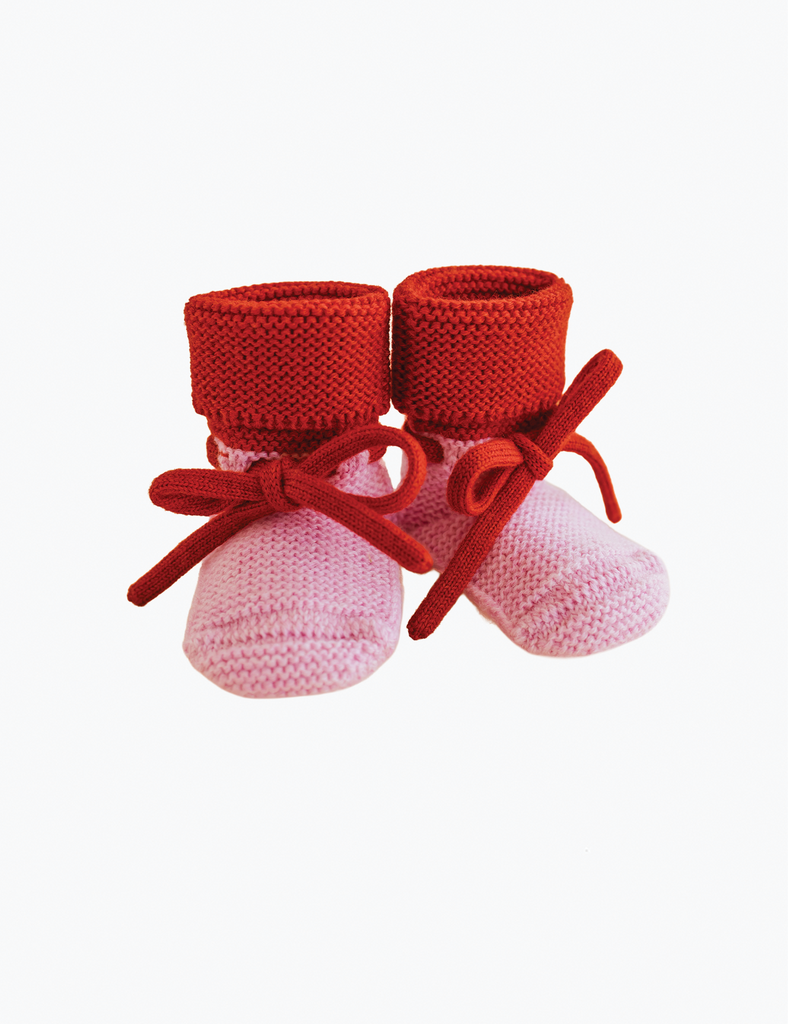 Image of pink and red baby booties on a white background.