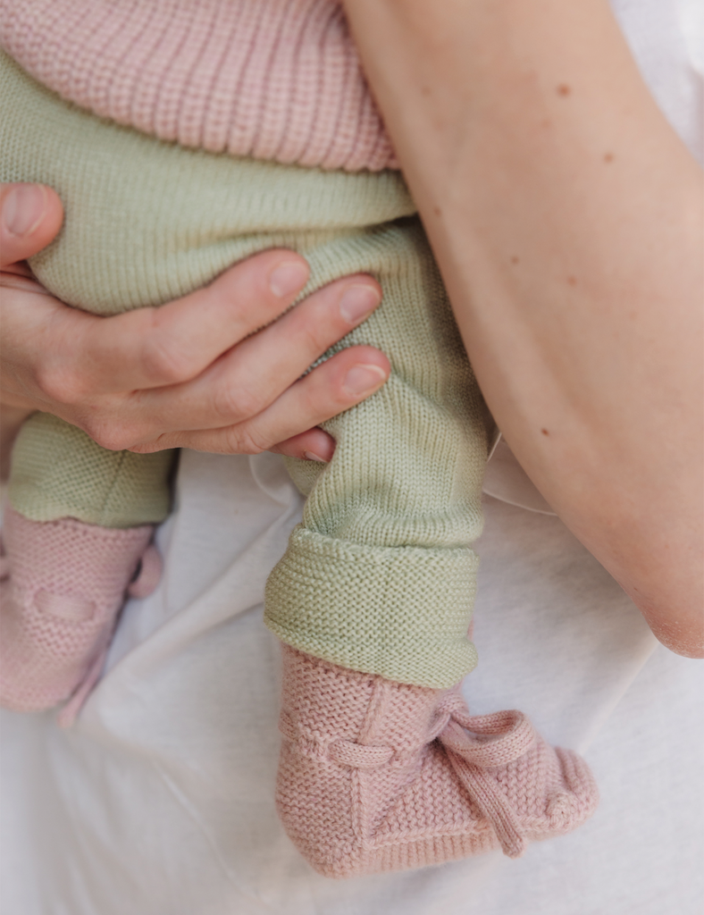 Image of pink booties on a baby