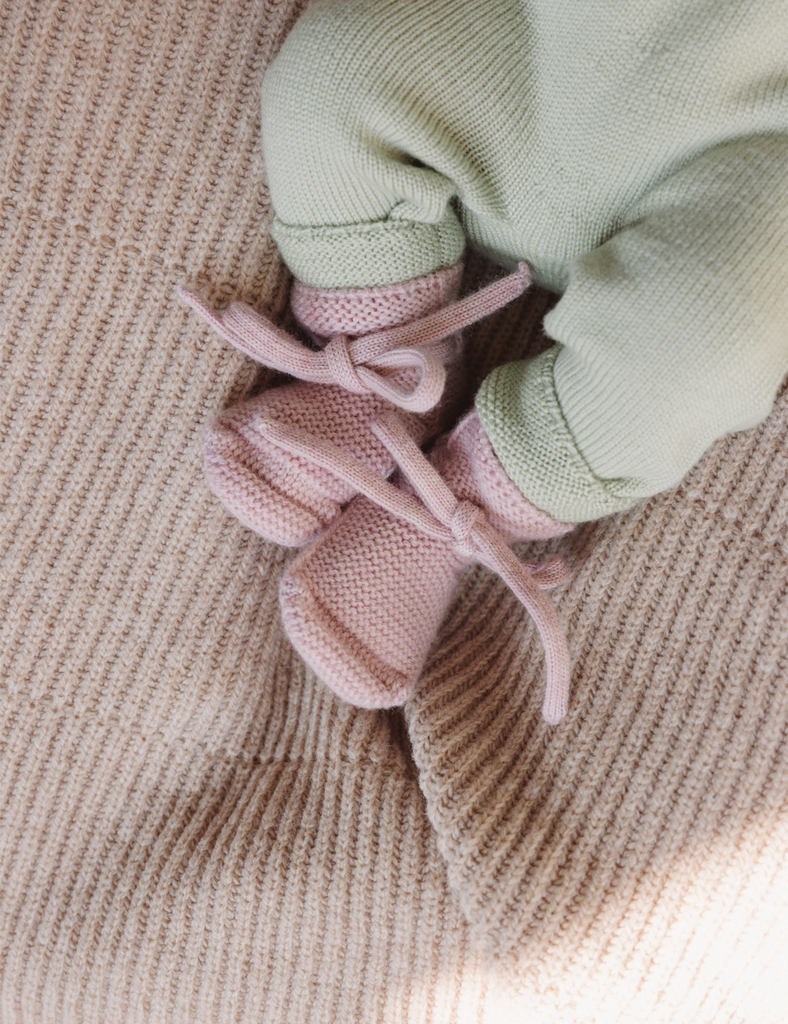Image of pink booties on a baby