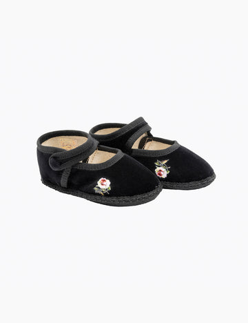 Pair of black slippers with floral embroidery on a white background