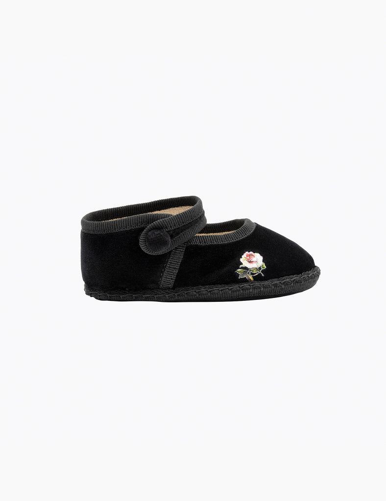 Black baby shoe with a rose detail on a white background