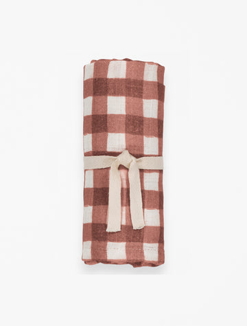 Baby swaddle in bourdeaux gingham flat lay image.