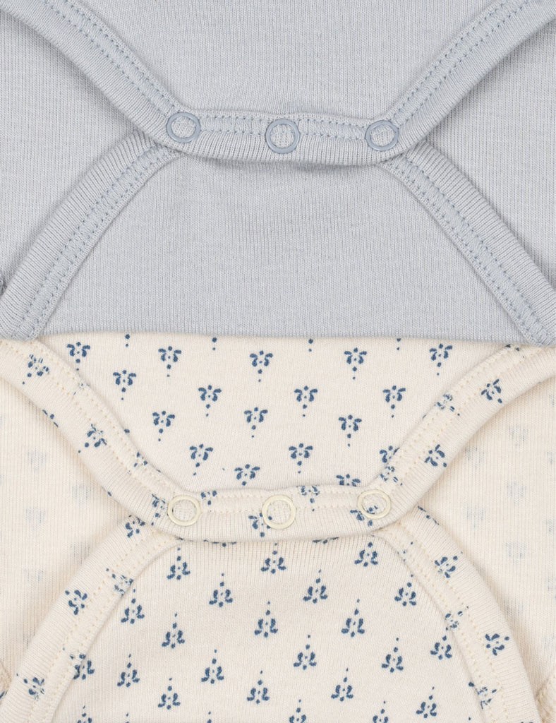 Close-up of a baby bodysuit with floral pattern and gray fabric above