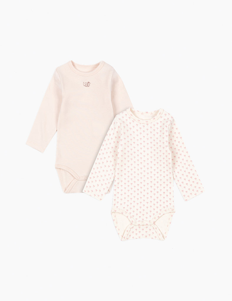 Two baby bodysuits on a white background, one plain and one with a pattern.