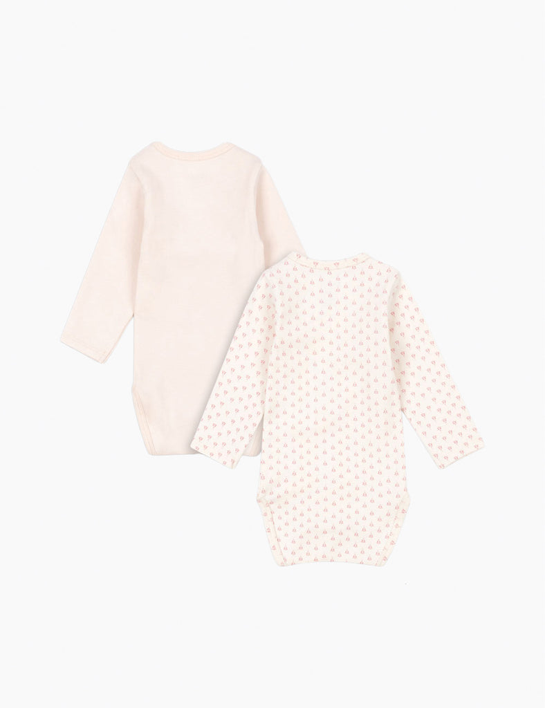 Baby outfit with light pink long-sleeve top and polka dot pants on a white background