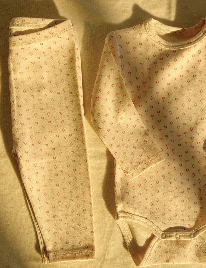 Set of baby leggings and shirt with a subtle pattern on a beige background