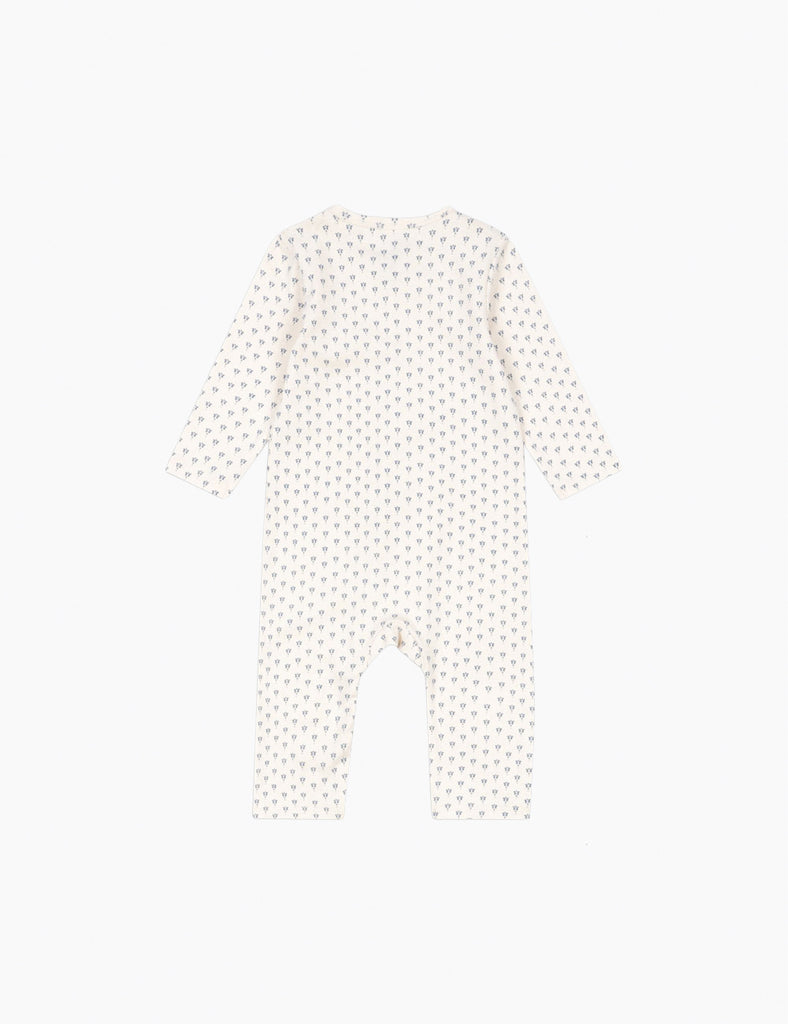 White baby onesie with small black polka dots on a white background