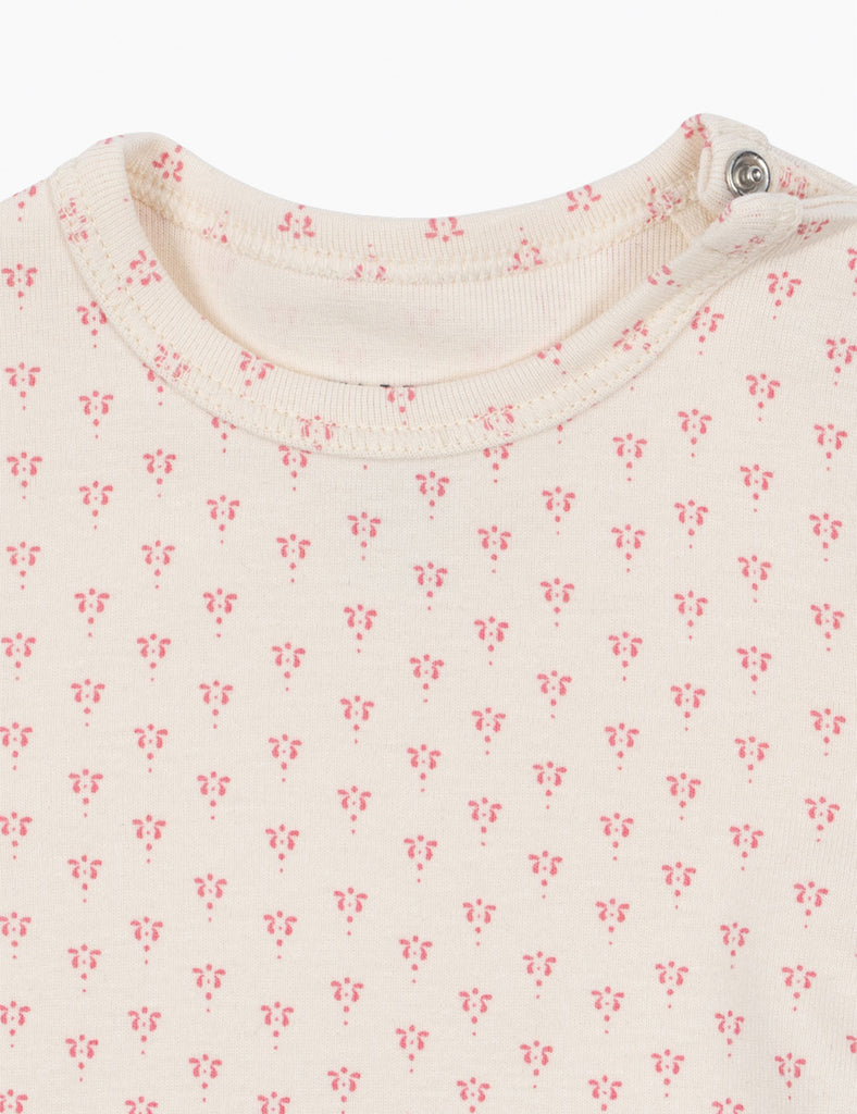 Close-up of a baby outfit with a floral pattern on a white background