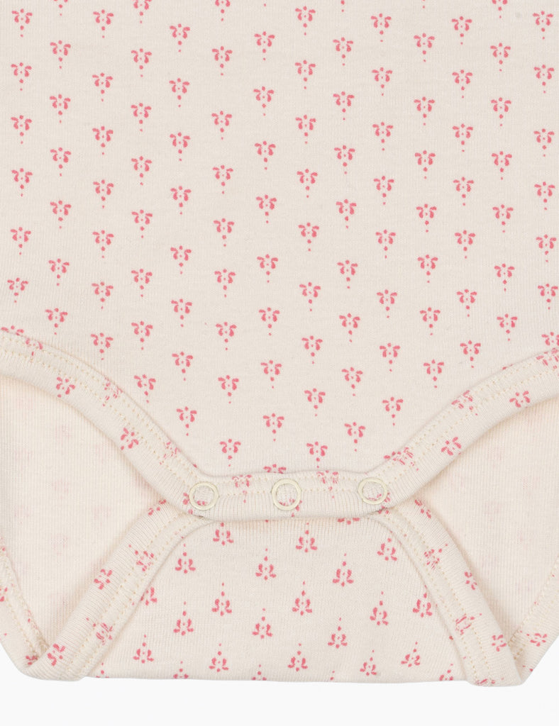 Close-up of a fabric with a small pink floral pattern on a white background