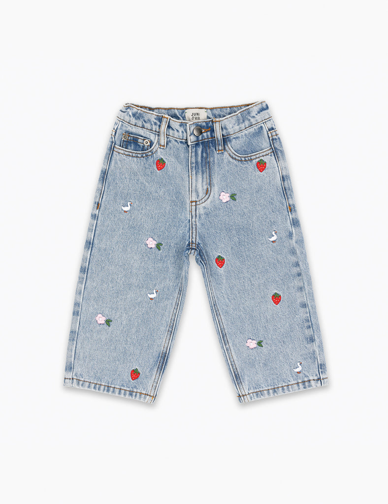 Light blue jeans with red heart and white flower embellishments on a white background