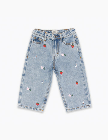 Light blue jeans with red heart and white flower embellishments on a white background
