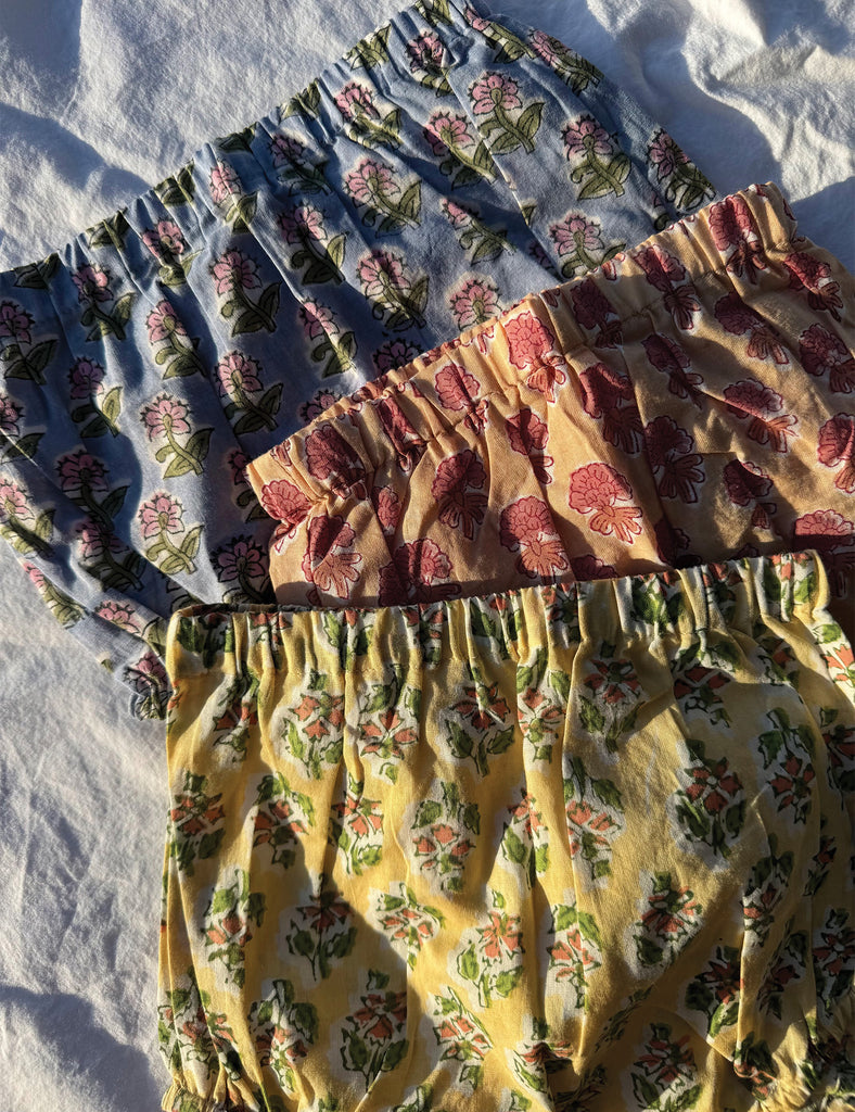 Three floral-patterned bloomers of different colors on a white background