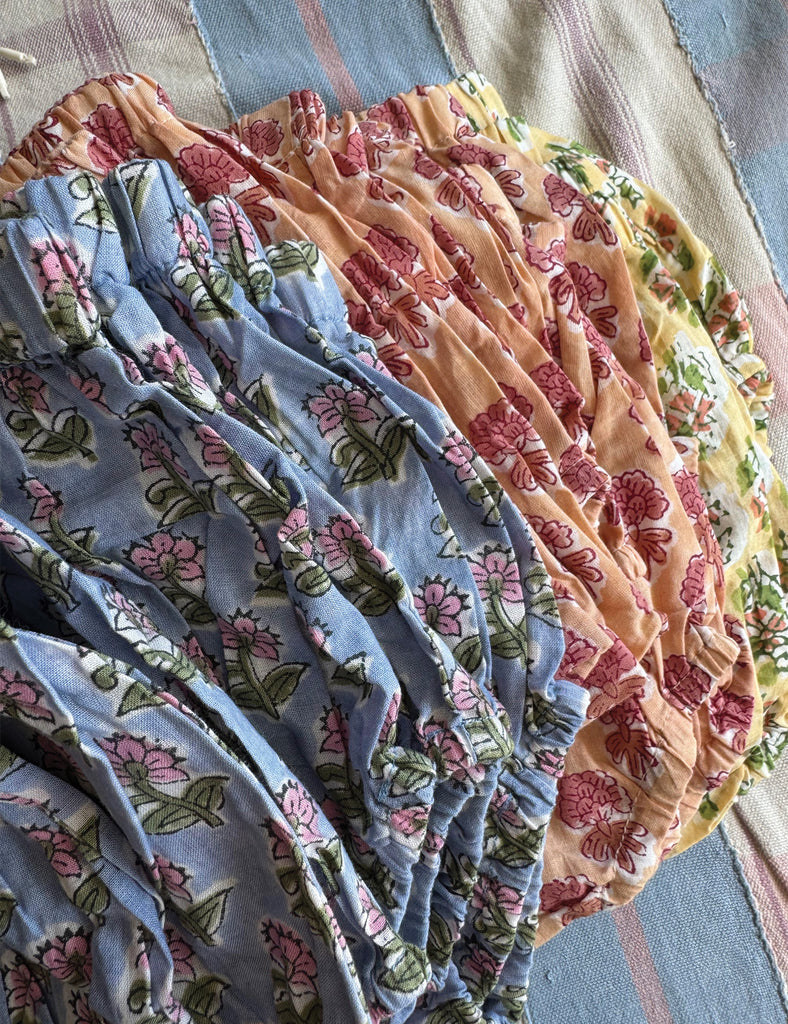 Stack of floral fabric baby bloomers in various colors.