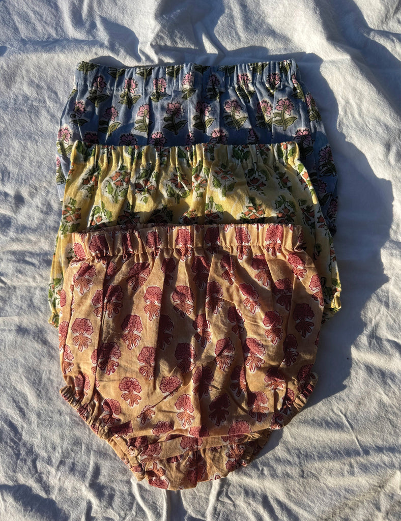 Two pairs of floral-patterned bloomers on a white fabric background