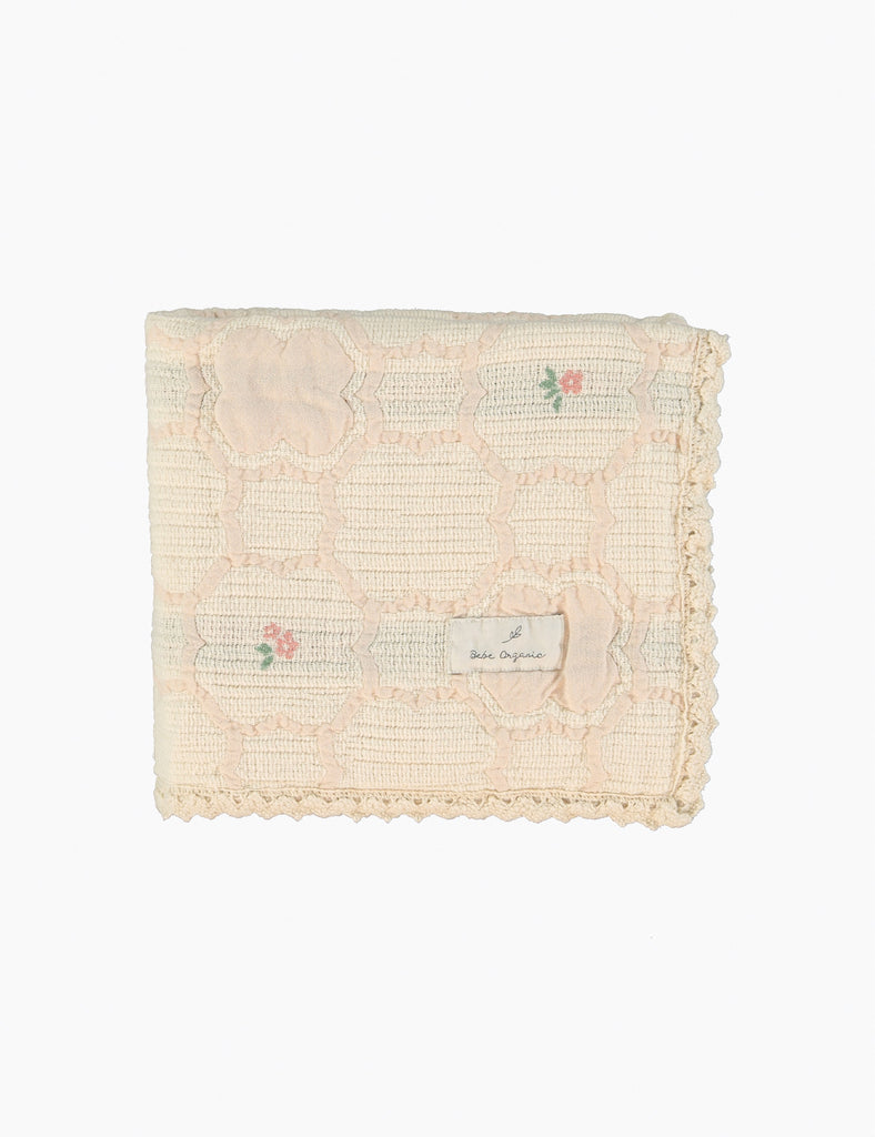 Textured blanket with floral embroidery on a white background