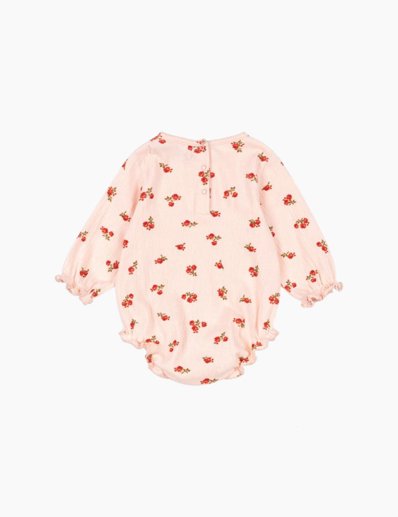 Pink baby romper with red floral pattern on a white background