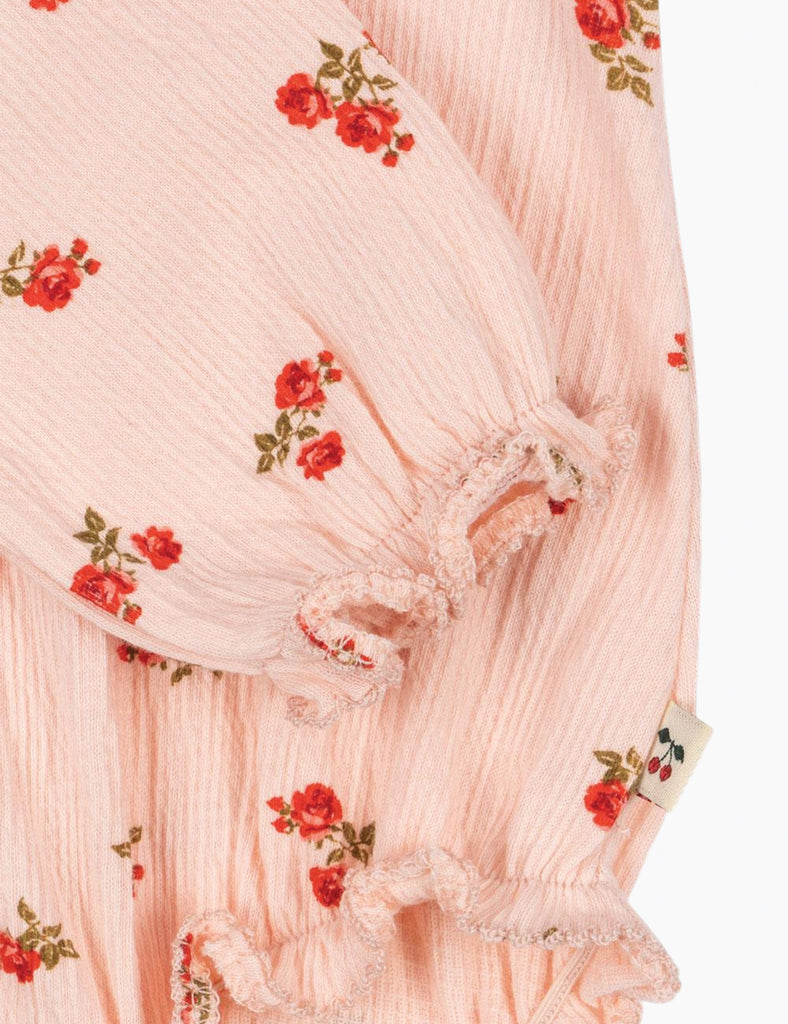 Close-up of a pink fabric with floral embroidery on a white background