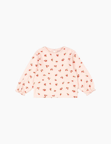 Pink long-sleeve top with small red floral pattern on a white background