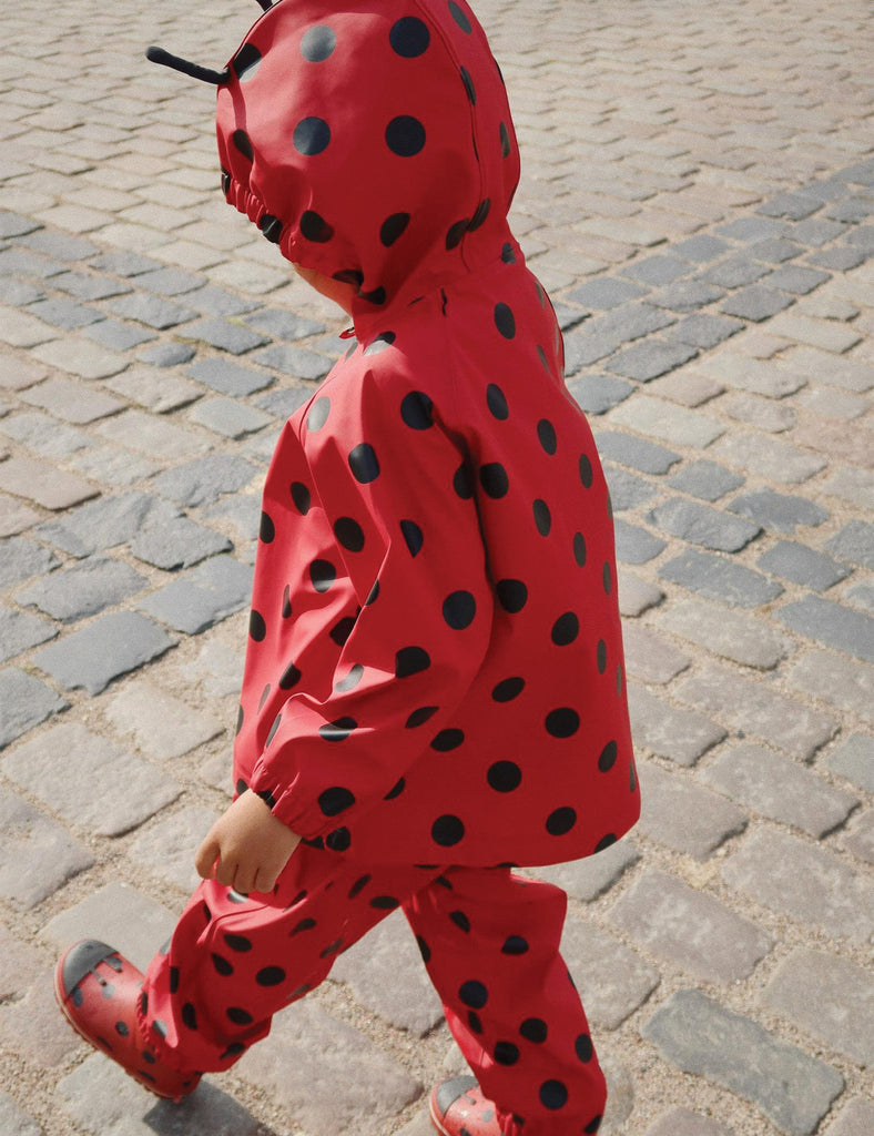 Image of a child wearing a matching hooded jacket and pant rain set. 