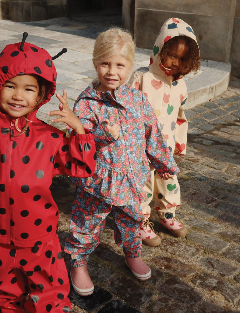 Image of a child wearing a matching hooded jacket and pant rain set. 