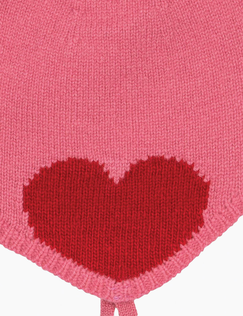 Pink knitted hat with a red heart design on a white background