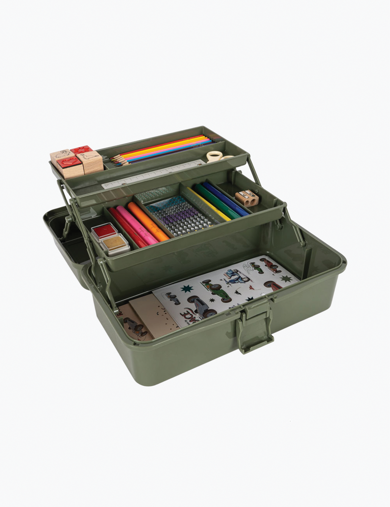 Green art supply case with various items on a white background